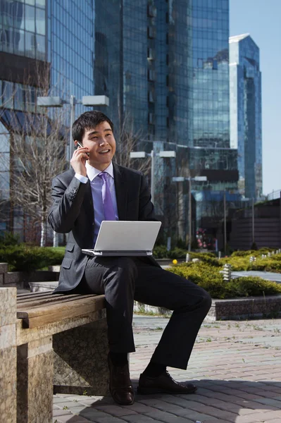 Joven hombre de negocios sentado con portátil. Exterior . — Foto de Stock