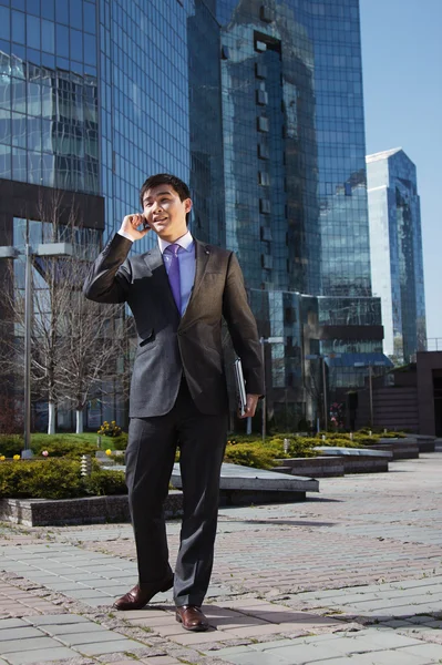 Tânăr om de afaceri în picioare și vorbind pe telefonul mobil — Fotografie, imagine de stoc