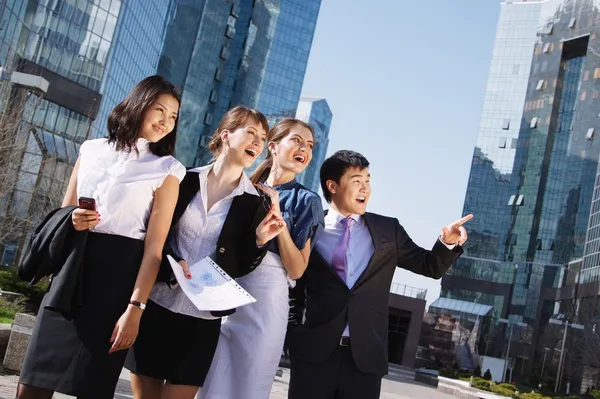 Glad mångskiftande grupp av chefer som pekar över businesscenter. — Stockfoto