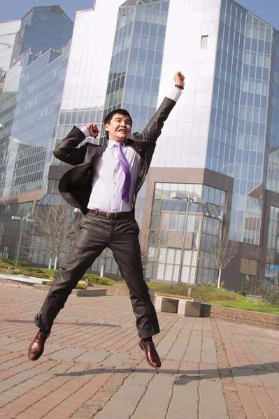 Jumping businessman over urban background — Stock Photo, Image