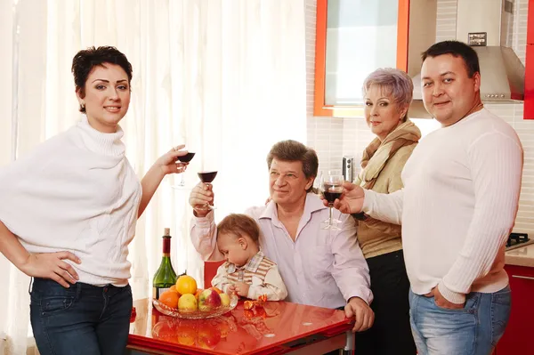 Family in home kitchen drinking wine — Stock Photo, Image