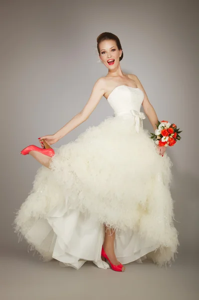 Happy bride holding heel — Stock Photo, Image