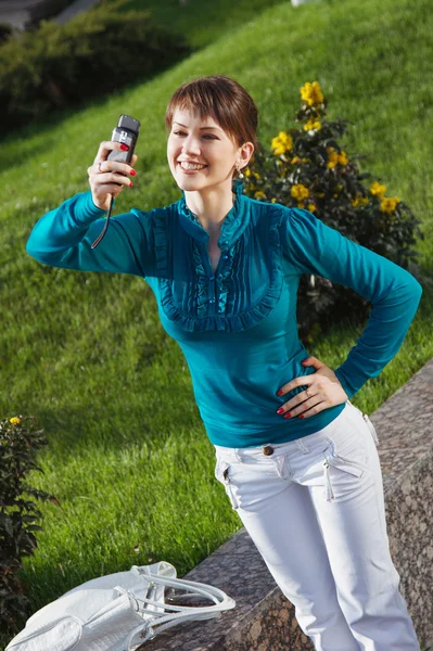 Kobieta pozuje do fotografii z jego telefonu komórkowego — Zdjęcie stockowe