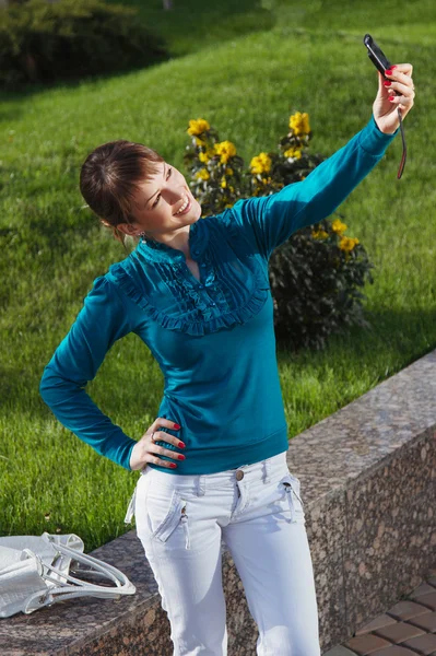 Woman posing for a photograph taken from his cell phone — Stock Photo, Image