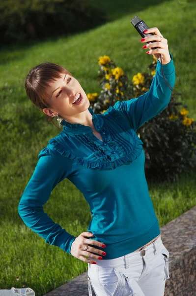 Mulher posando para uma fotografia tirada de seu celular — Fotografia de Stock