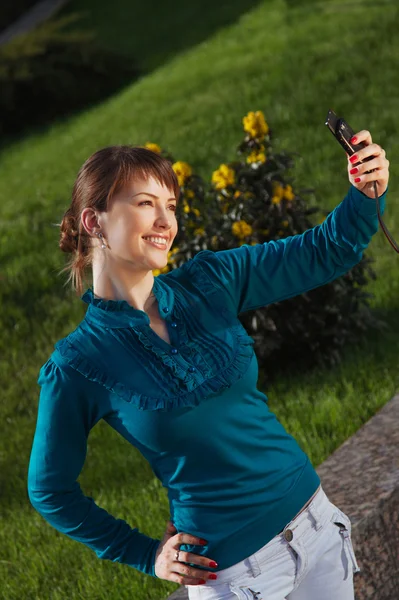 Mulher posando para uma fotografia tirada de seu celular — Fotografia de Stock