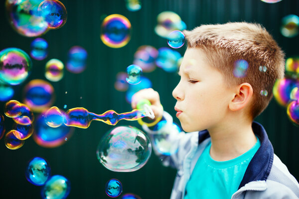 Kid making soap bubbles outside