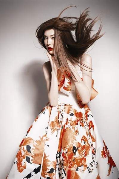 Young beautiful asian brunette in gorgeous Kravets dress, motion shot
