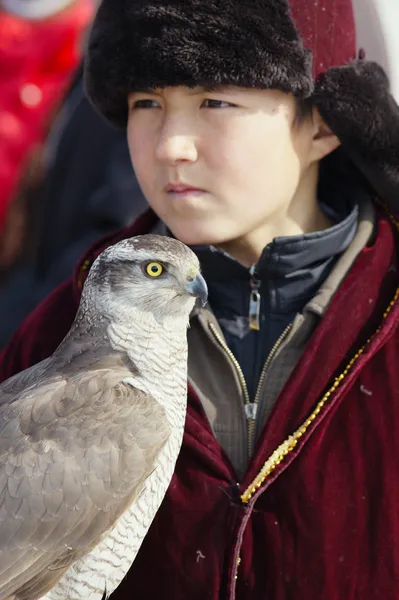 NURA, KAZAKHSTAN - FEBRUARY 23: Eagle on kid's hand in Nura near — Stock Photo, Image
