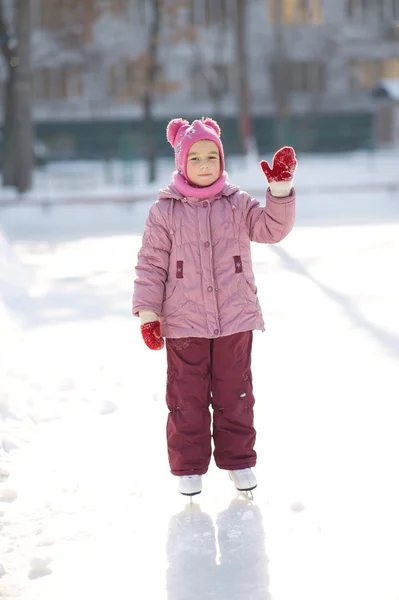 Beautiful smiling girl with skates over slide, ice rink backgrou — Stock Photo, Image