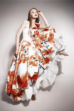 Young beautiful asian brunette in gorgeous Kravets dress. doll