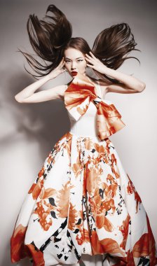 Young beautiful asian brunette in gorgeous Kravets dress, motion shot