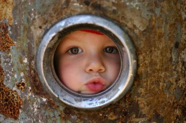 Kid looking through the round window clipart