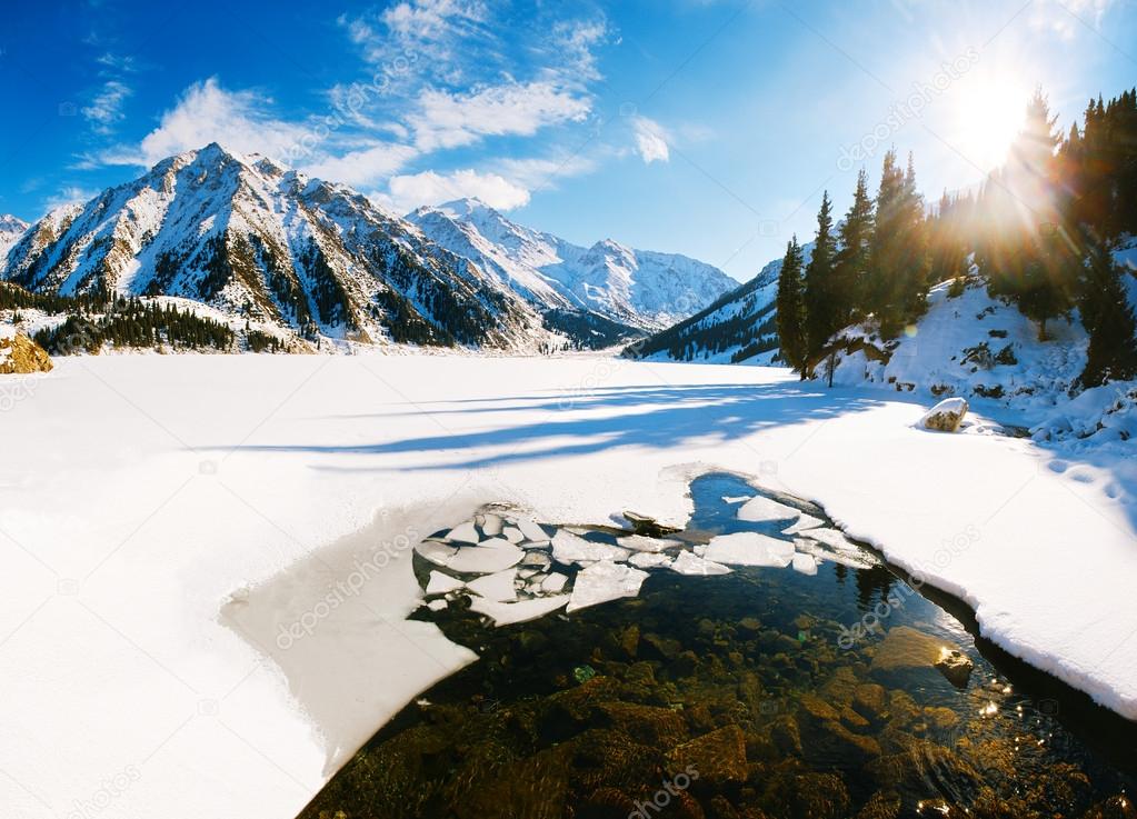 Big Almaty lake on december. Water, ice, mountains and snow.