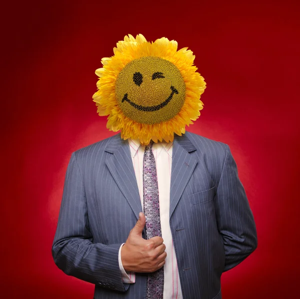 Uśmiechnięty słonecznika głowy człowieka w kolorze płaszcz z obecnych kciuki do góry o — Zdjęcie stockowe