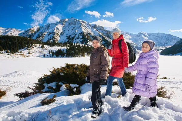 Keluarga (ibu dengan dua anak) berjalan-jalan di gunung musim dingin — Stok Foto