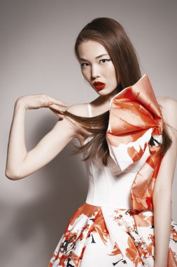 Shocked young beautiful asian brunette in gorgeous Kravets dress.