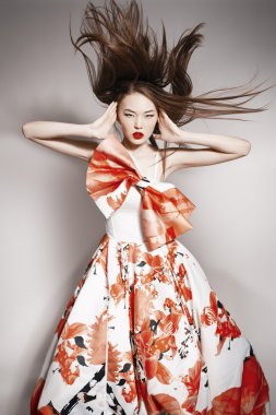 Young beautiful asian brunette in gorgeous Kravets dress, motion shot