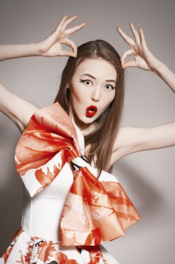 Young beautiful asian brunette in gorgeous Kravets dress. building horns