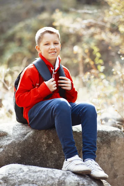 Happy smiling hiker boy with backpack in forest. Dressed in red — Stock Photo, Image