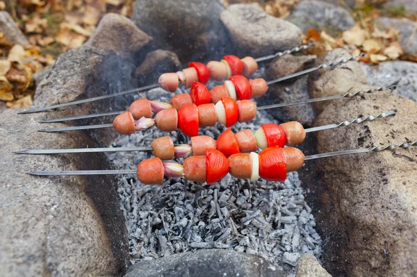 Gebackene rote Wurst mit Knoblauch, Zwiebeln und Tomaten auf dem Grill — Stockfoto