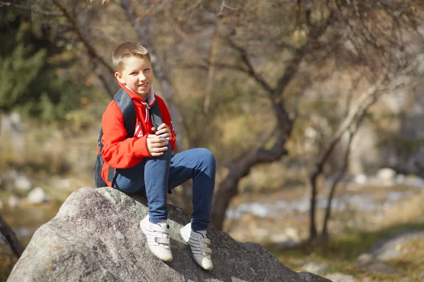 Happy smiling hiker boy with backpack in forest. Dressed in red — Stock Photo, Image