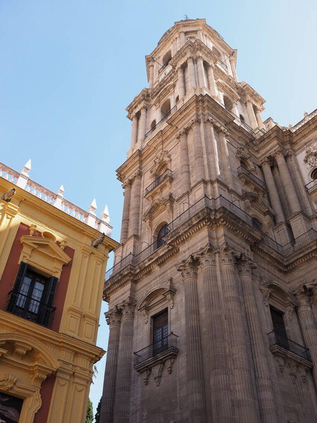 View to tower of cathedral in Malaga european city at Andalusia region in Spain, clear blue sky in 2019 warm sunny spring day on April - vertical