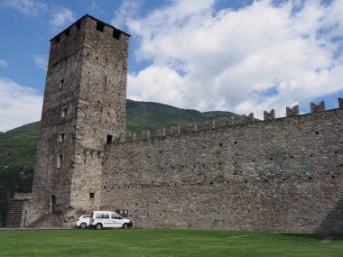 Stony wall and tower of castel grande in european Bellinzona city, canton Ticino in Switzerland, clear blue sky in 2017 warm sunny summer day on July.