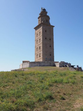 Avrupa 'daki Grassy Tepesi ve Herkül Kulesi İspanya' nın Galiçya şehrinde bir Coruna şehri, Eylül 'ün sıcak ve güneşli 2019' da açık mavi gökyüzü -