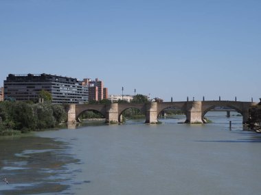 Stony bridge of lions and Ebro river in european Saragossa city at Aragon district in Spain, clear blue sky in 2019 warm sunny summer day on September