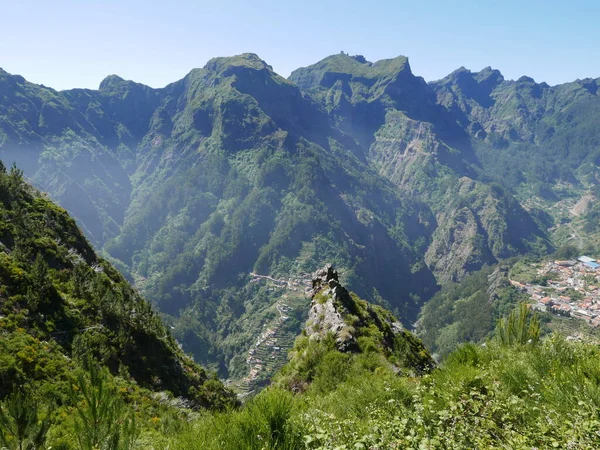 Foggy european Curral das Freiras village in nuns valley on Madeira island in Portugal, clear blue sky in 2022 warm sunny spring day on June.
