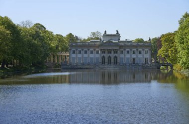 Palace on isle at lake in baths park in european Warsaw capital city of Poland in Masovian, clear blue sky in 2022 warm sunny spring day on May.