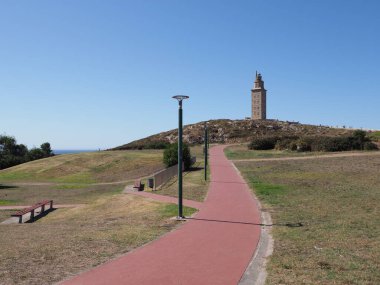 Red path to tower of Hercules in european A Coruna city at Galicia district of Spain, clear blue sky in 2019 warm sunny summer day on September.