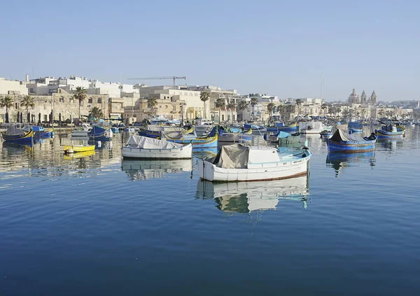 Malta 'daki MARSAXLOKK köyünde renkli tekneleri olan rıhtım, 2022' de açık mavi gökyüzü Mayıs ayında güneşli bahar günü.