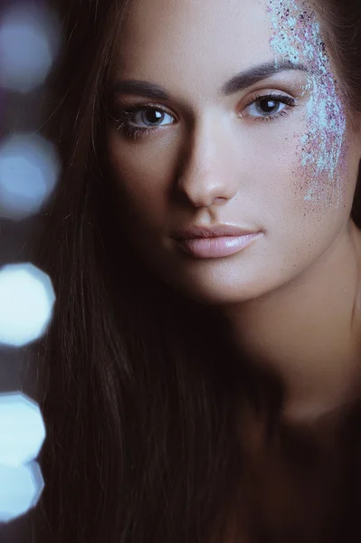 Mulher bonita com maquiagem festiva em pó spray de cor e luzes de boke — Fotografia de Stock