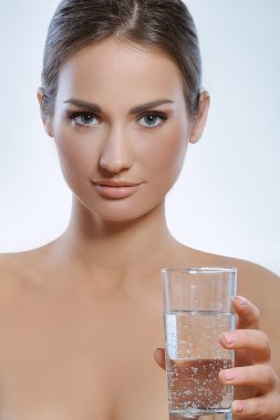 elinde bir bardak maden suyu tutan güzel bir genç kız