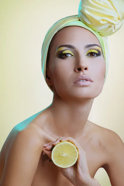 Beautiful health woman with lemon in yellow scarf on her head — Stock Photo, Image