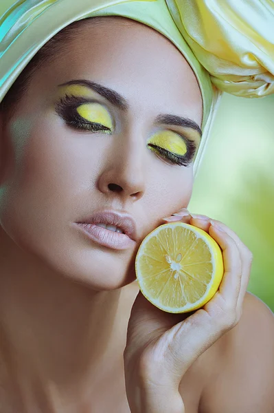 Beautiful health woman with lemon in yellow scarf on her head — Stock Photo, Image