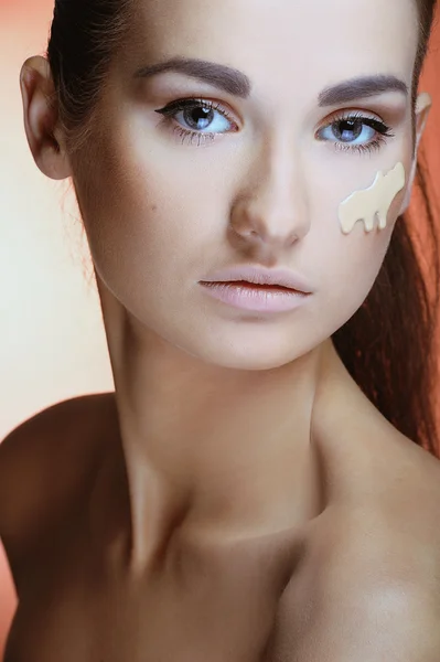 Beautiful woman with health fresh skin applying female makeup cream on her face — Stock Photo, Image