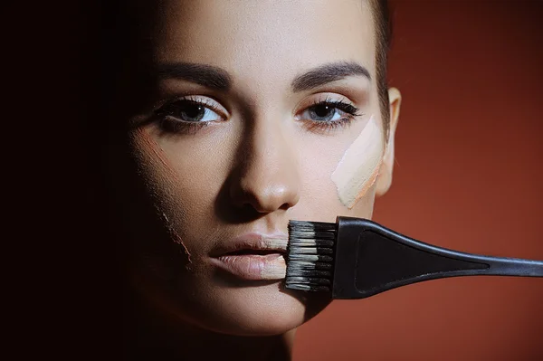 Belle femme avec la peau fraîche de santé appliquant la crème de maquillage féminine sur le visage — Photo