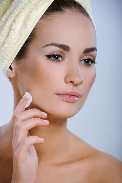 Belle jeune femme avec une peau parfaite appliquant des cosmétiques sur sa peau — Photo