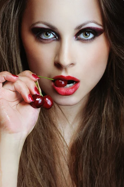 Young fashion woman with cherries in the mouth — Stock Photo, Image