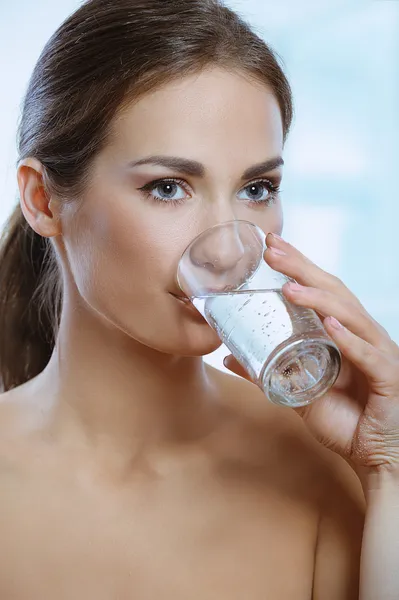 Healthy sport woman drinks mineral water from glass — Stock Photo, Image