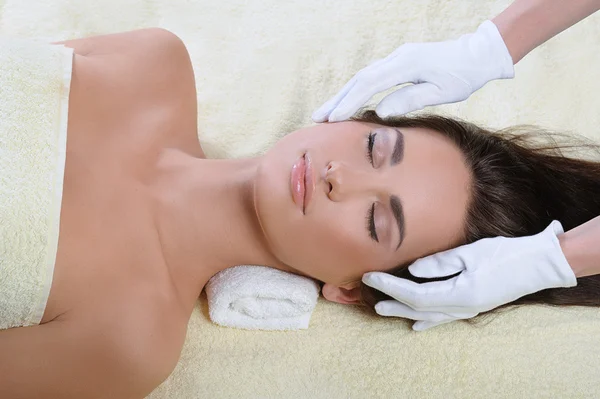 Молода жінка в спа-процедурах, масаж обличчя — стокове фото