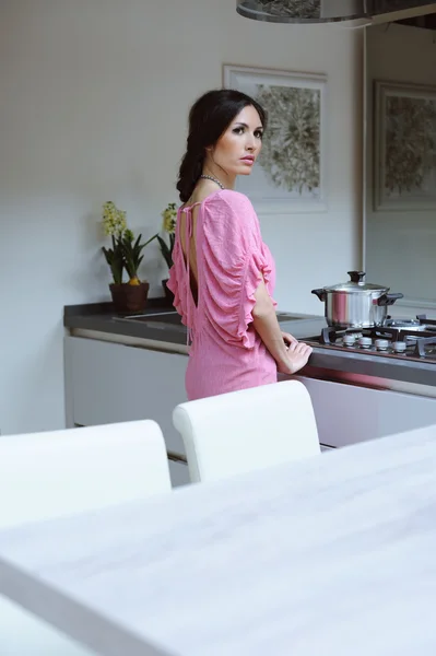 beautiful young woman cooking dinner in her kitchen