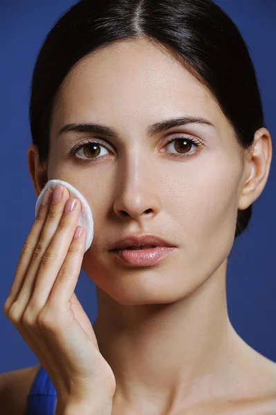 Closeup of beautiful young woman with health skin removes makeup from the face — Stock Photo, Image