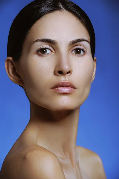 Closeup portrait of beautiful young sport girl with health skin of face on blue background — Stock Photo, Image