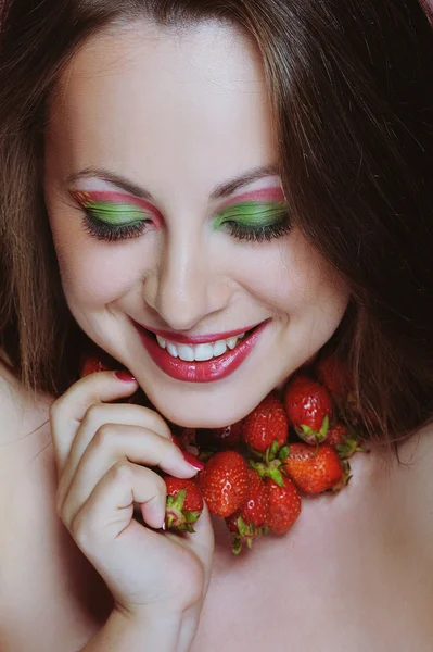 Young beautiful woman with white teeth enjoying strawberries — Stock Photo, Image