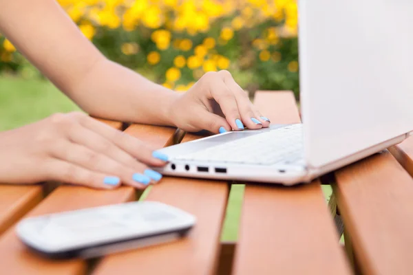 Kvinna med laptop och smartphone i trädgården — Stockfoto