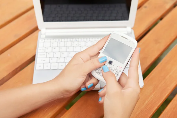 Vrouw met laptop en smartphone — Stockfoto